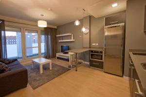 a living room with a couch and a kitchen at Apartamentos Irenaz in Vitoria-Gasteiz
