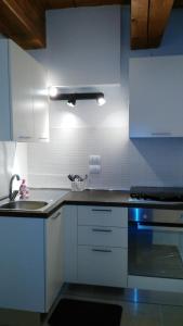 a kitchen with white cabinets and a sink and a stove at Lally House in Pesaro