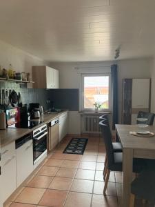 a kitchen with white cabinets and a table and a window at Ferienwohnung Bergblick in Winterberg