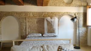 two beds in a room with a brick wall at Lally House in Pesaro