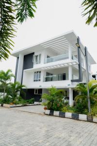 ein weißes Gebäude mit Palmen davor in der Unterkunft Mayns Executive room -blue in Chennai