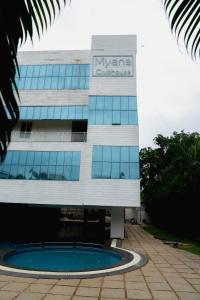 ein Gebäude mit einem Pool davor in der Unterkunft Mayns Executive room -blue in Chennai