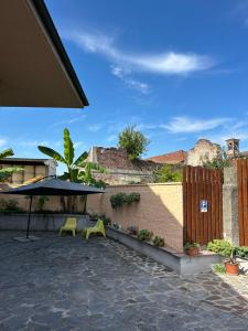 a patio with an umbrella and a table and chairs at Villa Luce in Casaletto Lodigiano