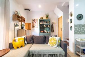 a living room with a gray couch with pillows at Casa Rubia Limón in Béznar +12 photos