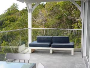 a blue couch sitting on a screened in porch at EDEN-RÉSIDENCE Le SAINT-BARTH Vue Mer et Piscine in Sainte-Luce