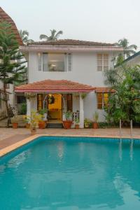 a house with a swimming pool in front of a house at 2 bedroom perfect stay villas in Anjuna