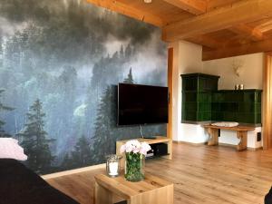 a living room with a large screen tv on a wall at Urbanshof Herr Tobias Fehrenbach in Hinterzarten