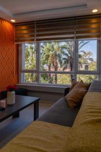 ein Wohnzimmer mit Couch und großem Fenster in der Unterkunft Maxihomes Near Hadrian Gate & Beach, with Sea Views in Antalya