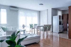 a living room with a white couch and a table at Evgeny's Stylishly Designed 2 Bedroom Apartment plus Garage! in Sofia