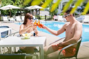 un homme et une femme assis à une table avec des boissons dans l'établissement Hotel Markushof, à Ora