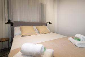 a bedroom with a bed with towels on it at Spacious New and Renovated Apartment in Plaza España with Stunning Terrace-Garden and Exquisite Decoration in Barcelona