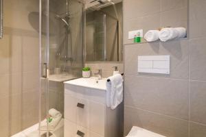 a bathroom with a sink and a shower at Spacious New and Renovated Apartment in Plaza España with Stunning Terrace-Garden and Exquisite Decoration in Barcelona