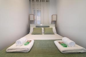 a bedroom with a bed with towels on it at Spacious New and Renovated Apartment in Plaza España with Stunning Terrace-Garden and Exquisite Decoration in Barcelona
