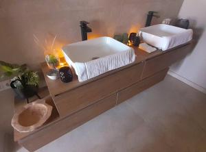 a bathroom with two sinks on a wooden counter at La Bergeronnette in Doudelainville