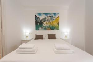 ein weißes Schlafzimmer mit einem großen weißen Bett mit zwei Lampen in der Unterkunft The Alou Apartment 2 - Montiboli - Private Beach in Villajoyosa + 21 Fotos