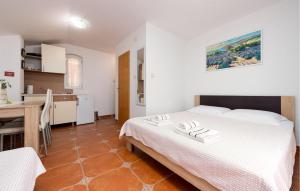 a bedroom with a bed and a table and a kitchen at Awesome Apartment In Karlobag With Wifi in Karlobag