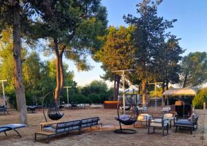 a park with benches and tables and trees at Imperial Paradise in Monopoli