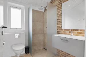ein Badezimmer mit Toilette und Waschbecken und einem Fenster in der Unterkunft LN1998 Hirtshals - Birksvej 6 in Hirtshals + 18 Fotos