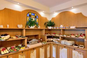 a kitchen with wooden cabinets and plates of food at Villa Casteria in Międzyzdroje