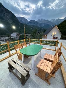 a table and chairs on a patio with mountains at GUEST HOUSE “ Center Theth “ in Theth