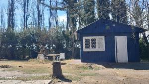 a blue shed with a table and a bench at Relajante cabañita rodeada de bodegas in Ciudad Lujan de Cuyo