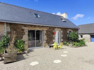 une maison en briques avec une terrasse en face de celle-ci dans l'établissement Les gîtes de L'hermine, à Plouigneau