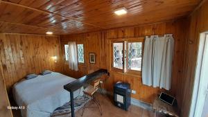 a bedroom with a bed in a wooden cabin at Relajante cabañita rodeada de bodegas in Ciudad Lujan de Cuyo