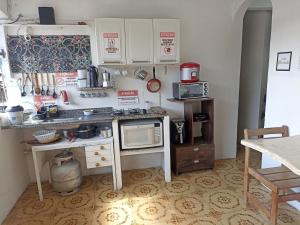 a kitchen with a counter with a microwave and a stove at Refúgio de Piratininga 204 in Niterói