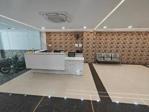 JāmbにあるHotel Budget Innのカウンターとバイクが置かれた広い部屋