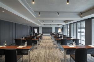 a row of tables and chairs in a room with windows at Radisson Hotel Don Mueang Bangkok in Bangkok