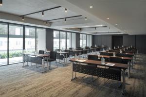 a dining room with tables and chairs and windows at Radisson Hotel Don Mueang Bangkok in Bangkok