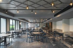 a dining room with tables and chairs and windows at Radisson Hotel Don Mueang Bangkok in Bangkok +43 photos