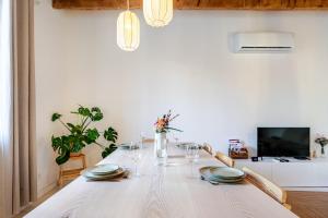 una sala da pranzo bianca con un tavolo bianco con sedie di Chaleureuse maison en centre ville a Perpignano