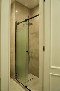 une douche avec une porte vitrée dans une salle de bain dans l'établissement Nest One, à Tachkent