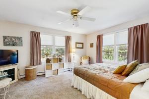 a bedroom with a bed and a tv and windows at White Mountain Getaway in Ossipee
