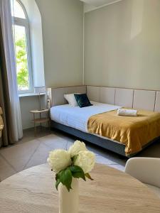 Un dormitorio con una cama y un jarrón con una flor en Zenao Appart'hôtels Marseille Prado, en Marsella