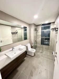 a bathroom with a toilet and a sink and a shower at Teega Suites, Puteri Harbour, Iskandar Puteri in Nusajaya