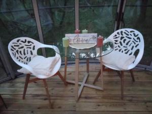 two chairs and a glass table with candles on it at A la bulle étoile 82 in Saint-Antonin +1 photo