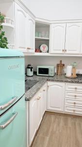 cocina con armarios blancos y nevera azul en Abades South Beach Domi, en Abades