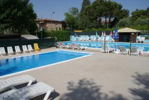 a swimming pool with lounge chairs and a swimming pool at Campeggio Bruno in Moniga