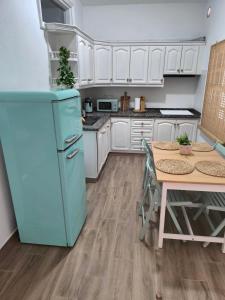 cocina con nevera azul y mesa en Abades South Beach Domi, en Abades