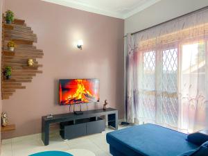 a living room with a tv on a wall at Shalom Homes in Kampala