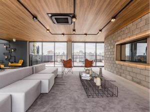 Una sala de estar con un sofá blanco y sillas. en GO Cidade Baixa by My Way, en Porto Alegre