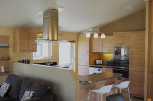 a kitchen with a couch and a table in a room at Morannedd Lodge Barmouth Bay in Llanddwywe