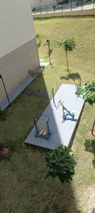 zwei Skulpturen von zwei Menschen, die auf einem Tisch auf einem Feld sitzen in der Unterkunft Studio Nossa Senhora Aparecida - Condominium of Faith in Cachoeira Paulista