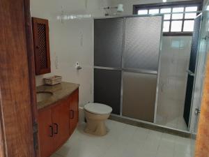 a bathroom with a shower and a toilet and a sink at Casa Grande da praia de Piratininga in Niterói