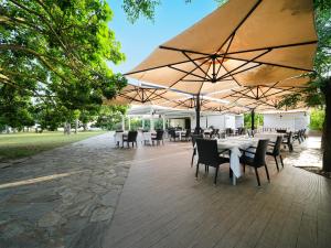 a restaurant with tables and chairs and umbrellas at Le Dune Resort in Menfi