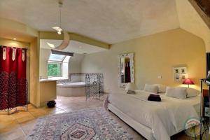 a bedroom with a large bed and a bathroom at Lariboisiere in Javené +25 photos