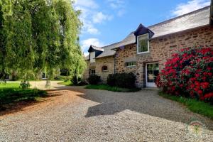 a stone house with a gravel driveway at Lariboisiere in Javené