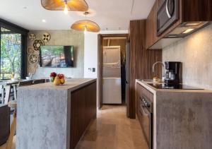 a kitchen with a large island in the middle at Ideal Location with Cenote Pools Gym Restaurant in Tulum +28 photos